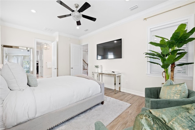 bedroom featuring crown molding, wood finished floors, visible vents, and baseboards