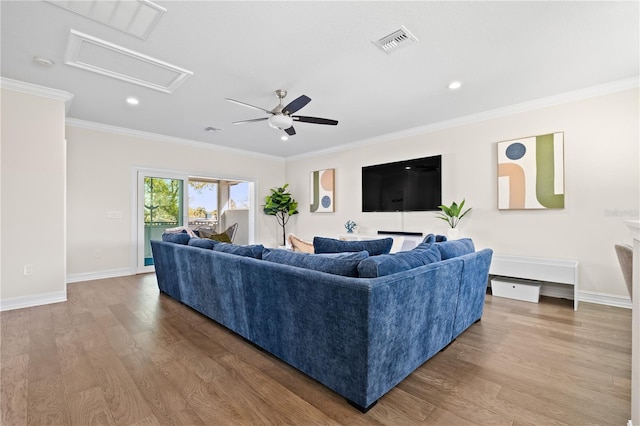 living area featuring visible vents, wood finished floors, a ceiling fan, and ornamental molding