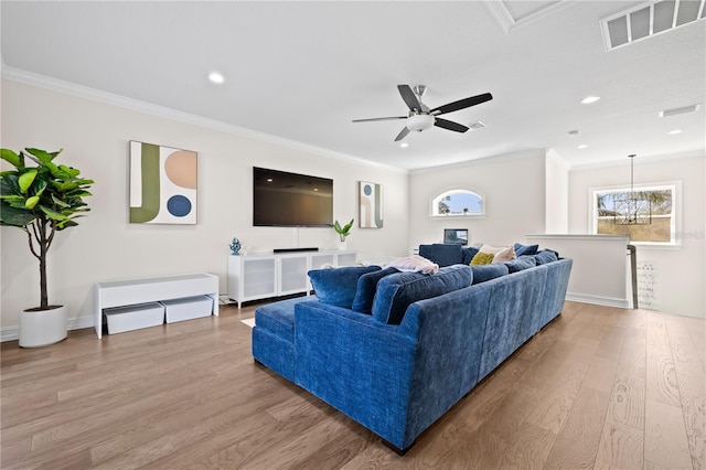 living room featuring crown molding, recessed lighting, light wood-style floors, and visible vents