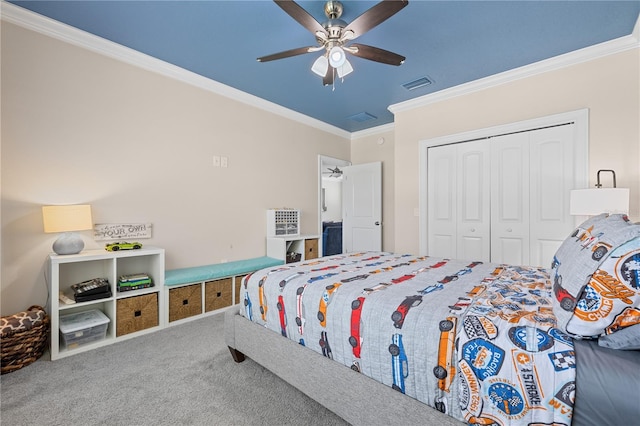 carpeted bedroom with crown molding, a ceiling fan, visible vents, and a closet