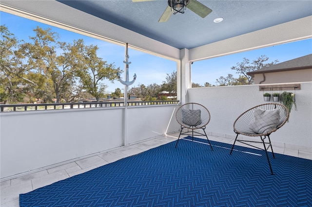 unfurnished sunroom featuring a ceiling fan