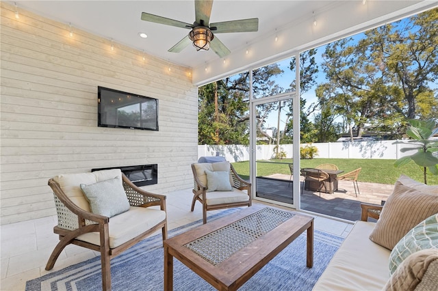 sunroom featuring an outdoor brick fireplace and ceiling fan