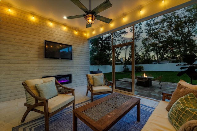 view of patio with an outdoor living space with a fire pit, a fenced backyard, and a ceiling fan