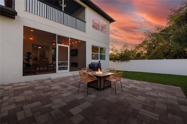 view of patio / terrace featuring an outdoor fire pit, a balcony, and fence