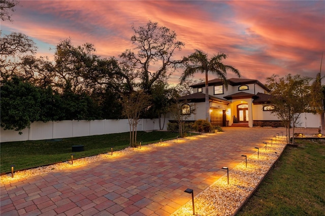 exterior space with stucco siding, a front lawn, and fence