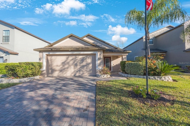 view of front of home with a front lawn, decorative driveway, a garage, and stucco siding