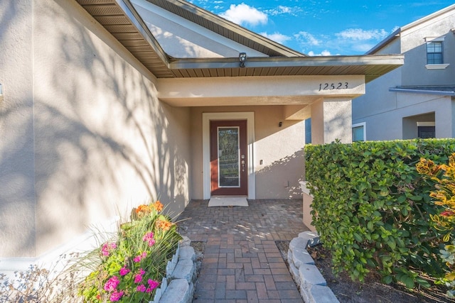 view of exterior entry featuring stucco siding