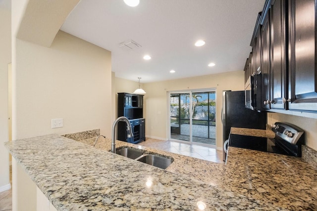 kitchen with light stone counters, visible vents, a peninsula, a sink, and electric stove