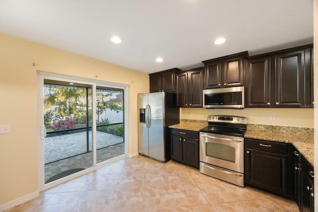 kitchen featuring recessed lighting, stainless steel appliances, light stone countertops, and baseboards