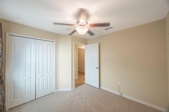 unfurnished bedroom with carpet, visible vents, baseboards, ceiling fan, and a closet