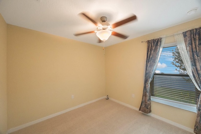 carpeted empty room with baseboards and ceiling fan