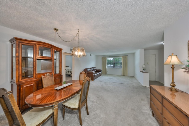 dining space with a notable chandelier, light colored carpet, and a textured ceiling