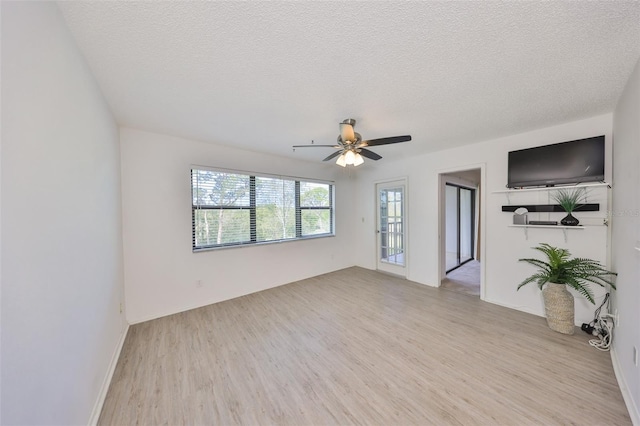 unfurnished room with light wood-style flooring, a textured ceiling, and a ceiling fan