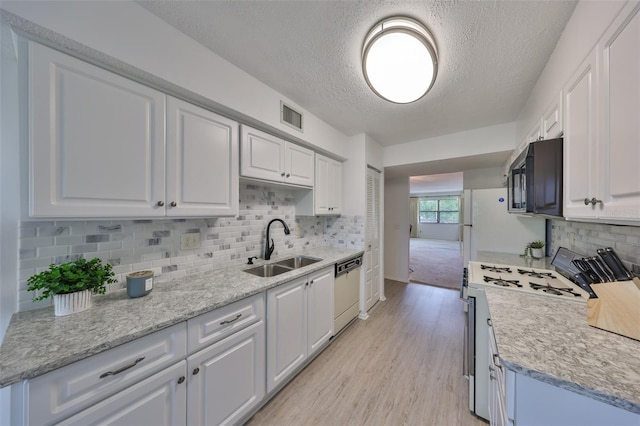 kitchen with visible vents, black microwave, dishwasher, range with gas stovetop, and a sink