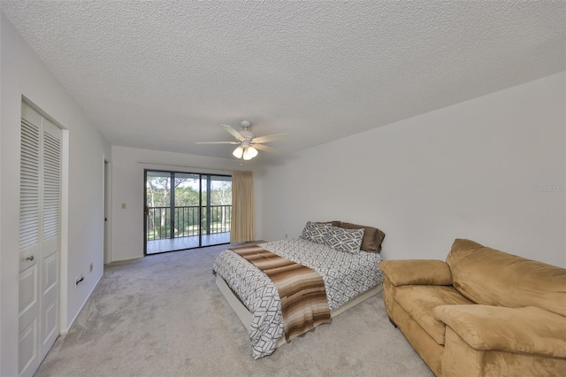 bedroom with ceiling fan, access to exterior, a closet, a textured ceiling, and light carpet