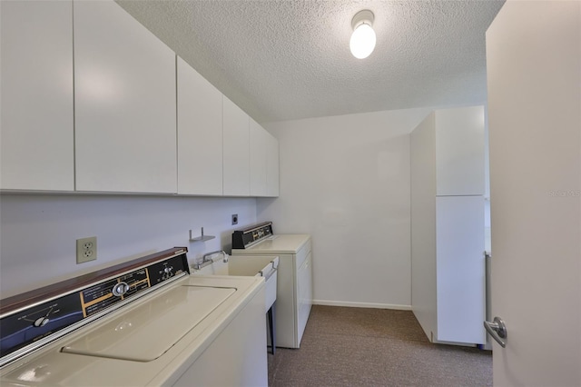 laundry area with baseboards, carpet, washer and dryer, cabinet space, and a textured ceiling