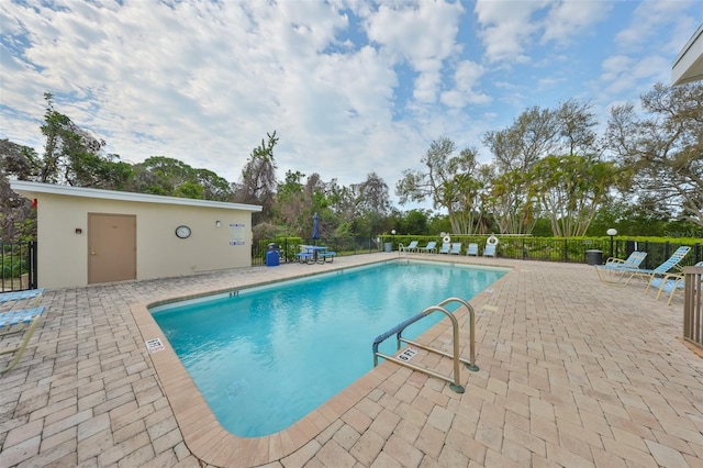 community pool with a patio and fence