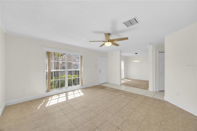 empty room with light tile patterned floors, a ceiling fan, visible vents, and a textured ceiling