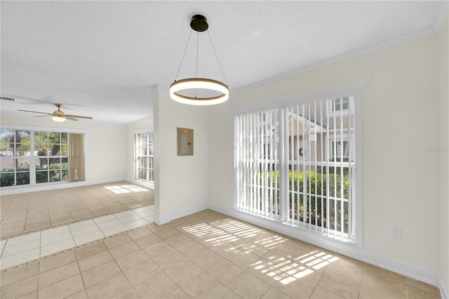 tiled empty room with visible vents, a ceiling fan, a textured ceiling, crown molding, and baseboards