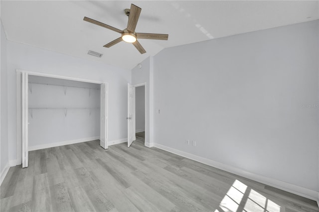 unfurnished bedroom featuring visible vents, baseboards, wood finished floors, and vaulted ceiling