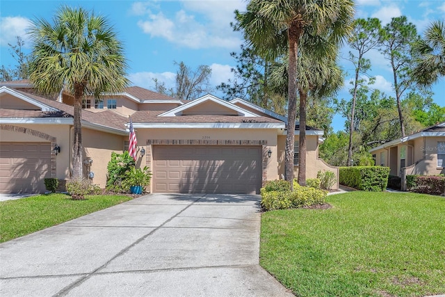 view of front of house featuring a front lawn, concrete driveway, a garage, and stucco siding