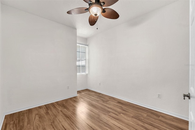 empty room with a ceiling fan, baseboards, and wood finished floors