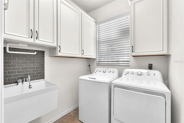 washroom featuring baseboards, separate washer and dryer, cabinet space, a sink, and tile patterned floors