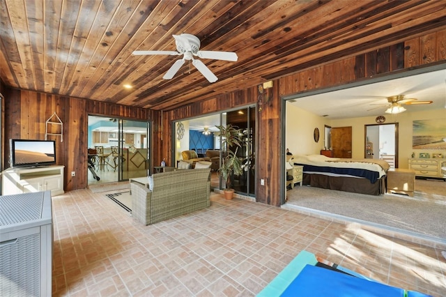 interior space with wood walls, wood ceiling, brick floor, and ceiling fan