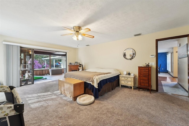 carpeted bedroom with visible vents, a textured ceiling, access to exterior, and a ceiling fan