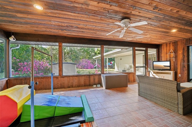 unfurnished sunroom featuring wood ceiling and ceiling fan