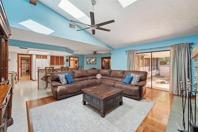 living area featuring ceiling fan, visible vents, light wood-type flooring, and a skylight