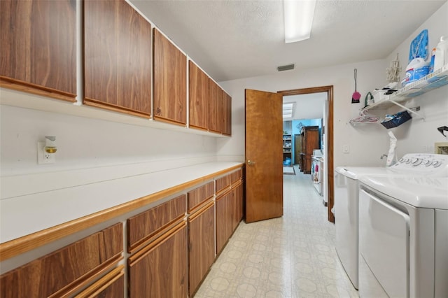 laundry room with light floors, visible vents, separate washer and dryer, cabinet space, and a textured ceiling