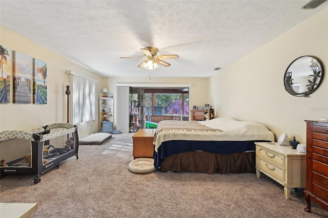 bedroom with access to exterior, visible vents, carpet flooring, a textured ceiling, and a ceiling fan