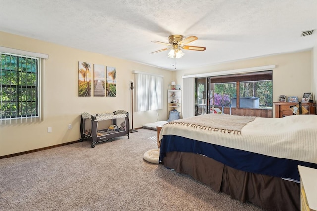 carpeted bedroom with multiple windows, baseboards, visible vents, and a textured ceiling