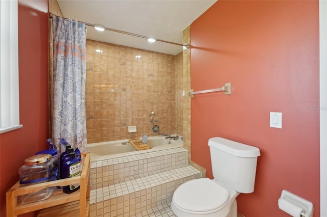 full bathroom with toilet and tiled shower / bath