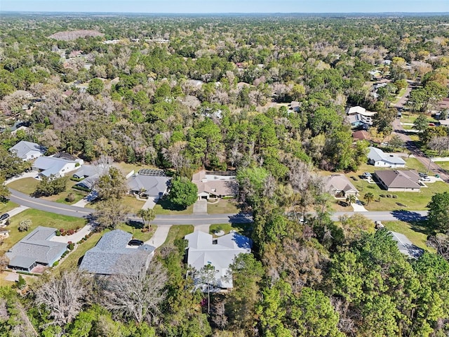 drone / aerial view featuring a wooded view and a residential view