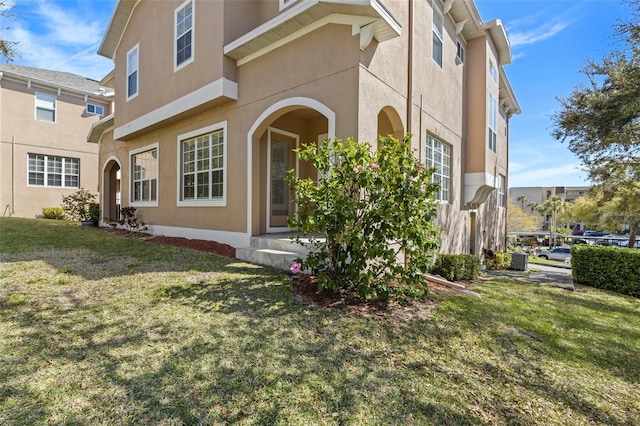 exterior space featuring stucco siding, central air condition unit, and a yard