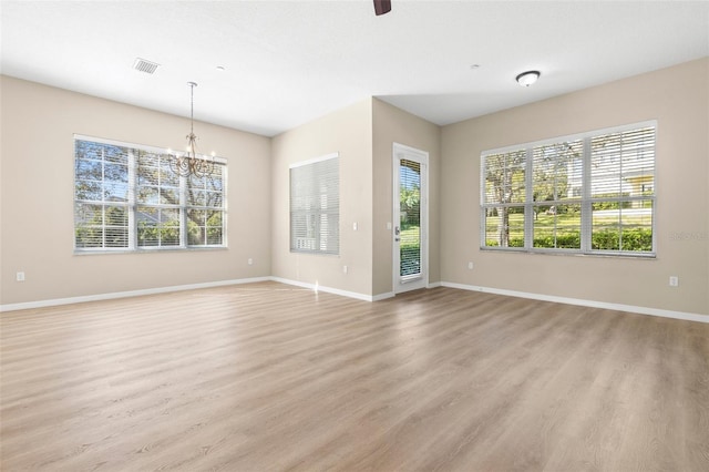 unfurnished living room with visible vents, light wood-type flooring, and baseboards