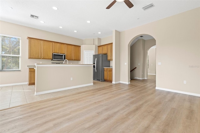 kitchen with visible vents, brown cabinets, stainless steel appliances, and open floor plan