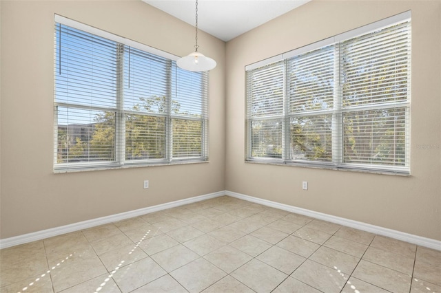 unfurnished room featuring light tile patterned floors and baseboards