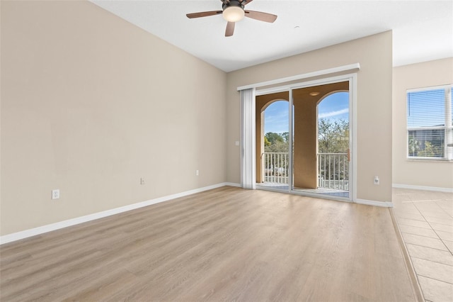 empty room with light wood-style flooring, a healthy amount of sunlight, baseboards, and ceiling fan