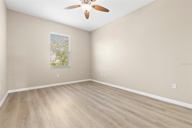 spare room featuring light wood-type flooring, baseboards, and a ceiling fan