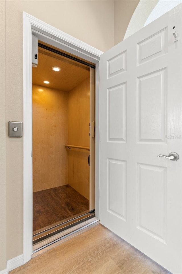 room details featuring elevator and wood finished floors