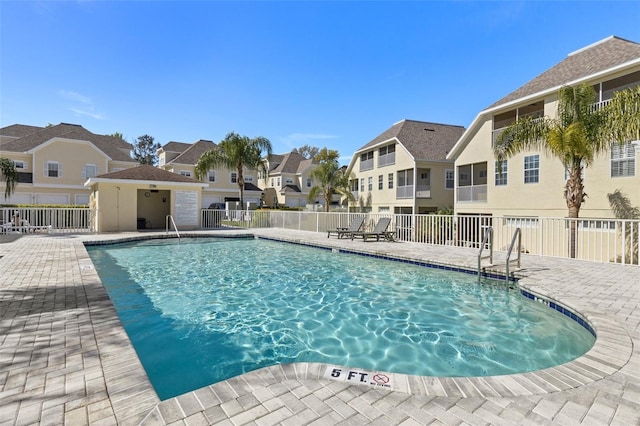 pool featuring a residential view, a patio, and fence