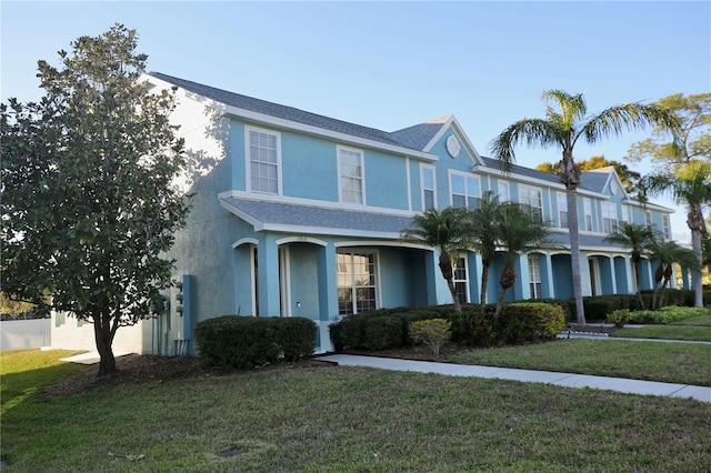 view of front of property featuring stucco siding and a front lawn