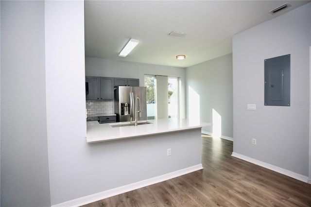 kitchen with visible vents, electric panel, stainless steel fridge with ice dispenser, decorative backsplash, and dark wood-type flooring