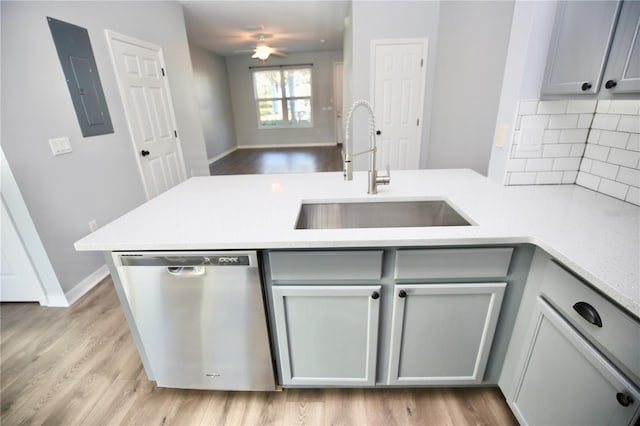 kitchen featuring stainless steel dishwasher, gray cabinetry, electric panel, and a sink