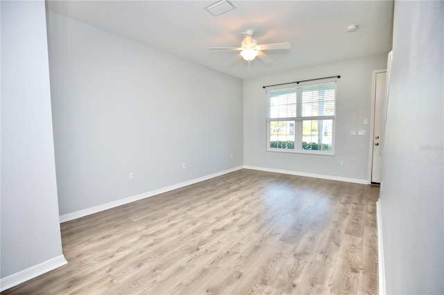 empty room with visible vents, wood finished floors, baseboards, and ceiling fan