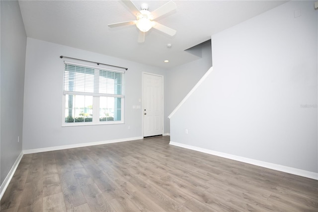 empty room featuring wood finished floors, recessed lighting, a ceiling fan, and baseboards