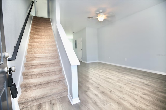 stairs with baseboards, a ceiling fan, and wood finished floors